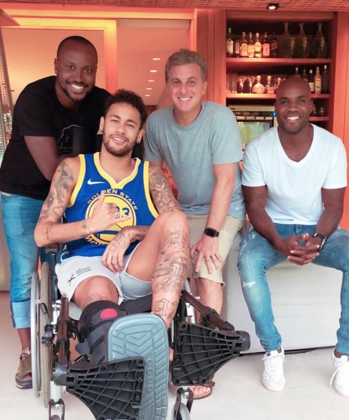 Neymar recebe visita de Luciano Huck e Thiaguinho após cirurgia 